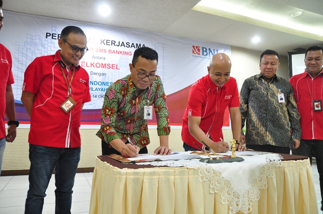 Pimwil Padang BNI, S Hidayat Safwan (dua kiri) dan GM Digital Products Sales Sumatera Telkomsel Yudi Chahyadi Anwar (tiga kanan) mengesahkan Program Kerja Sama SMS Banking Telkomsel dan PT BNI (Persero).